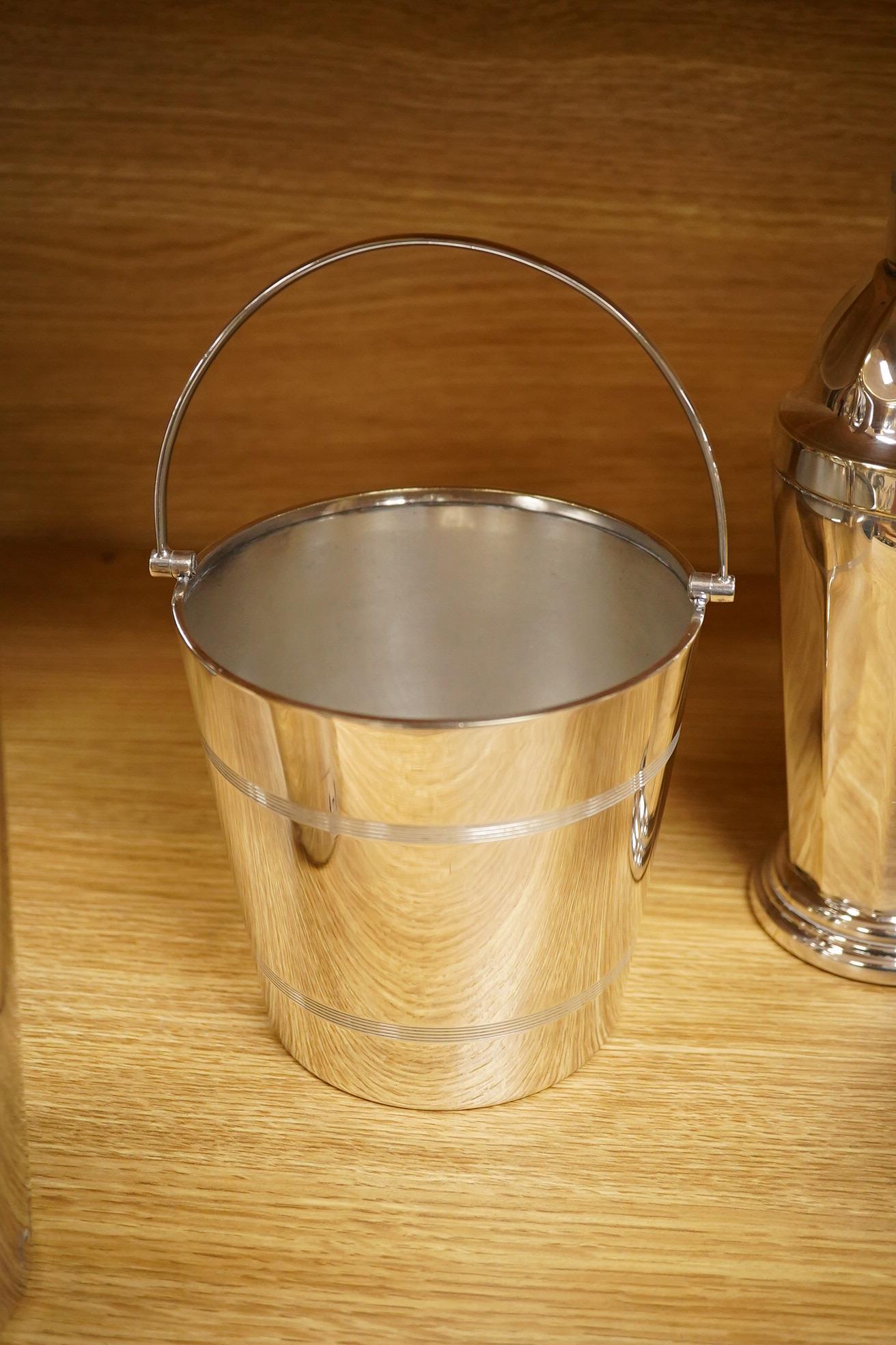 A mid 20th century silver plated patent cocktail shaker with recipes, two other cocktail shakers and an ice bucket, largest 28cm high